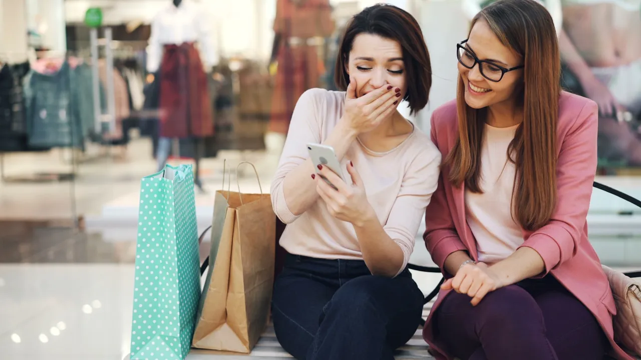 Two friends laughing at something on a phone